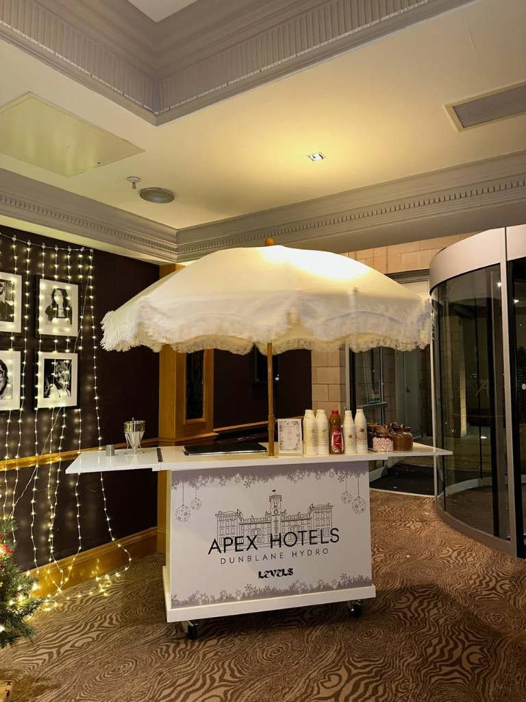 Luxury Apex Hotels Dunblane Hydro hospitality cart with fringed umbrella and Levels branding