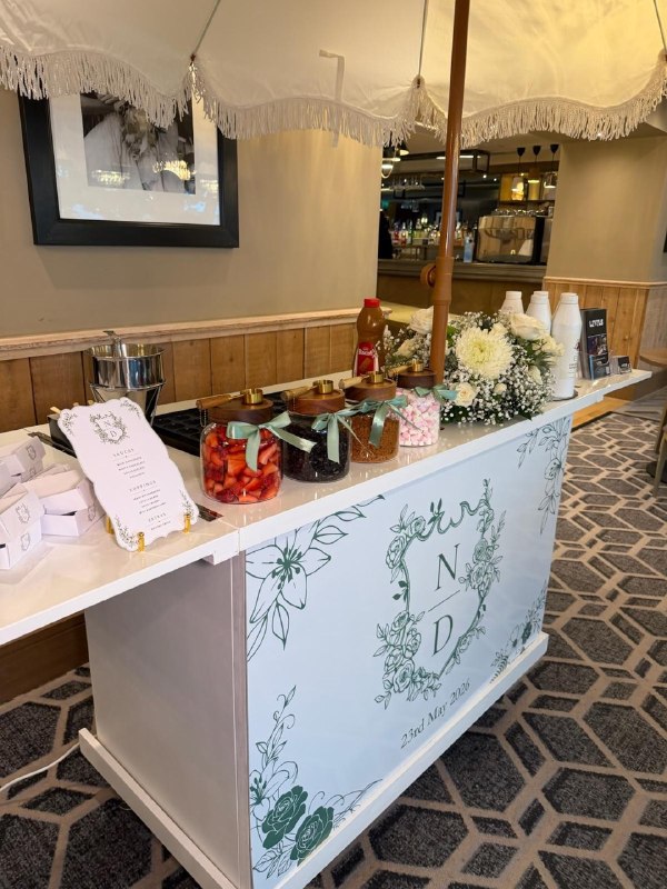 Wedding pancake cart with gourmet topping jars, sauces, menu card, and floral display