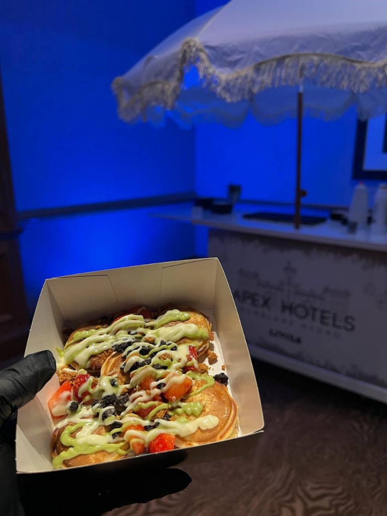 Gourmet mini pancakes in a tray with Apex Hotels cart in the background